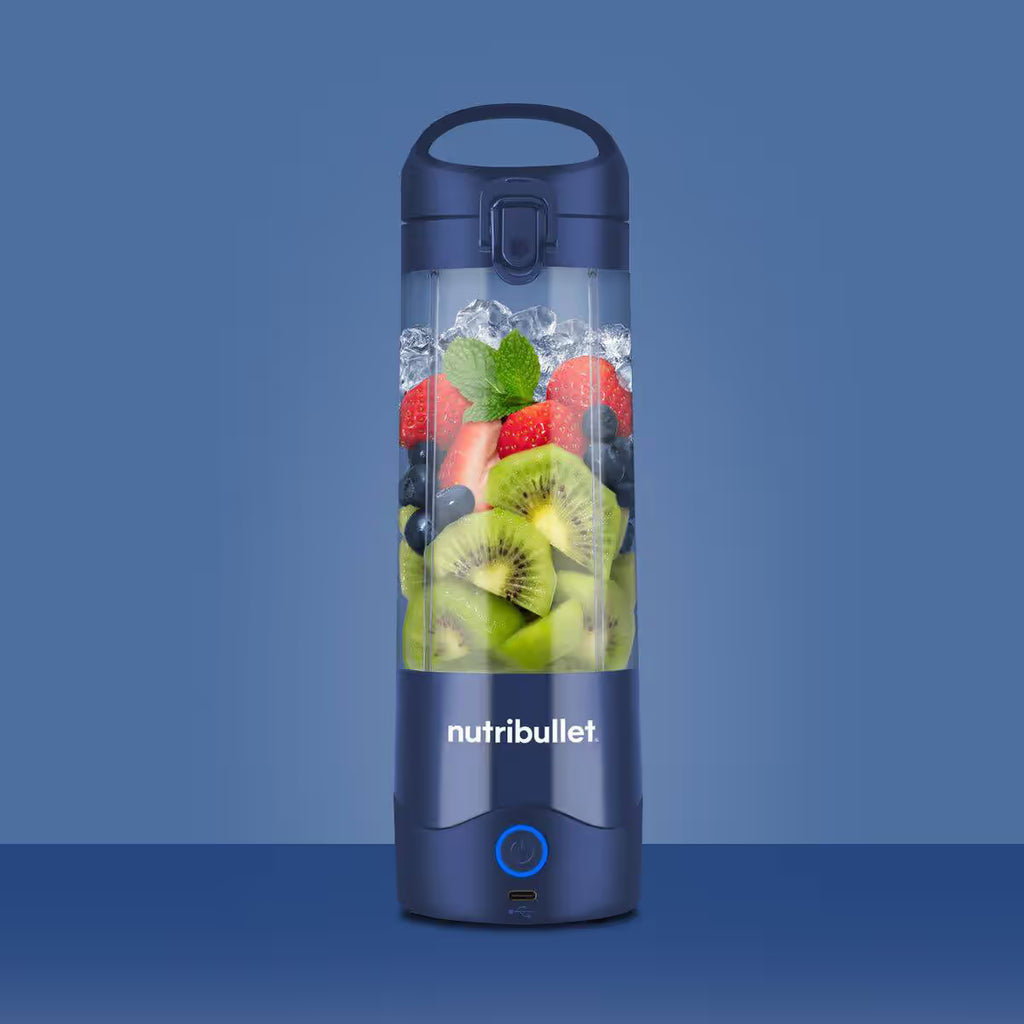 Vista frontal de la licuadora portátil Nutribullet Portable azul de 16oz con frutas e hielo sobre fondo azul - Ferretería La Palma - 1690100