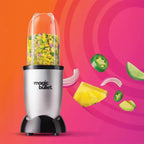 Vista frontal de la licuadora personal Magic Bullet Original de 250W con ingredientes picados dentro del vaso sobre un fondo gráfico de color naranja y rosa con frutas y verduras flotando - Almacén La Palma - 1690001