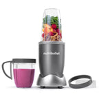Vista frontal de la licuadora personal Nutribullet Original de 600W con frutas, nueces y vegetales en el vaso principal, un licuado de frutos del bosque en el vaso con anillo con asa y un anillo de comodidad - Almacén La Palma - 1690000