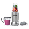 Licuadora personal Nutribullet Original 600W en color plateado con vaso lleno de frutas fresas, batido preparado y tapa sobre fondo blanco - Ferretería La Palma - 1690080