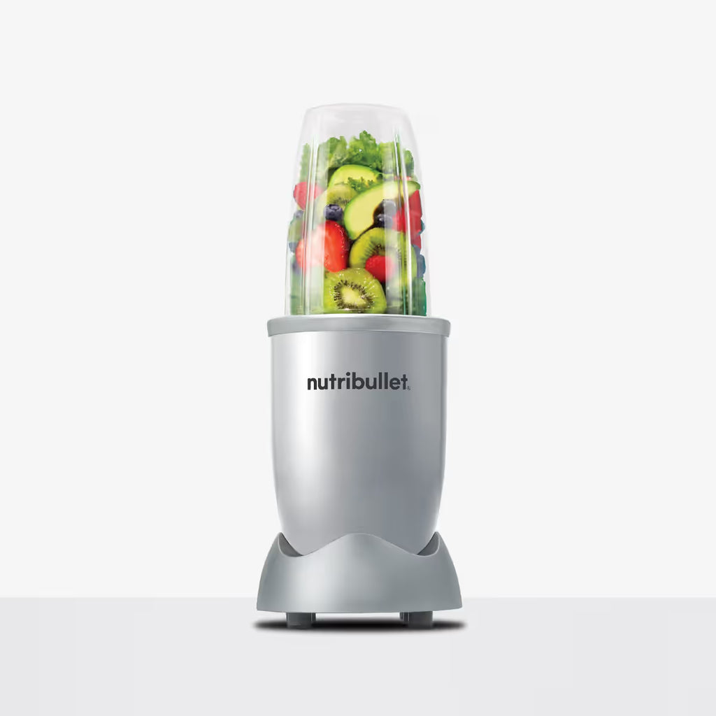 Licuadora personal Nutribullet Original 600W en color plateado con vaso lleno de rodajas de kiwi, aguacate y fresas frescas sobre fondo blanco - Ferretería La Palma - 1690080