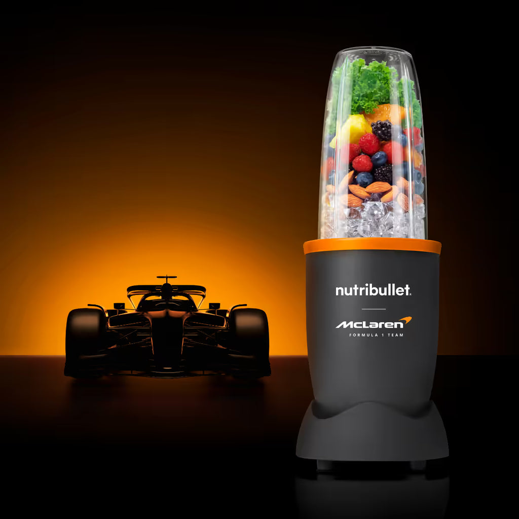 Licuadora personal Nutribullet Pro 900 edición McLaren F1 Team con vaso lleno de frutas y silueta de auto de carreras - Ferretería La Palma - 1690079