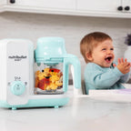 Procesador Nutribullet Baby Steam y Blend con trozos de manzana y coliflor en el vaso junto a un bebé sonriendo en la cocina - Ferretería La Palma - 1690018