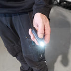 Mano sosteniendo la lámpara portátil Scangrip FLEX WEAR con el foco linterna frontal encendido - Ferretería La Palma - 1870002