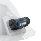 Primer plano de la lámpara LED industrial Scangrip HORIZON instalada en la base adhesiva en un casco de seguridad blanco sobre fondo blanco - Ferretería La Palma - 1870003