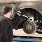 Mecánico iluminando el sistema de frenos y la suspensión en el paso de rueda de un coche con la lámpara de inspección LED tipo barra Scangrip LINE LIGHT C+R - Ferretería La Palma - 1870007