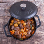 Vista superior en perspectiva del horno holandés Victoria de 3.8 litros en hierro fundido curado con un estofado de carne, papas y zanahorias sobre una mesa de madera rústica - Ferretería La Palma - 1050045