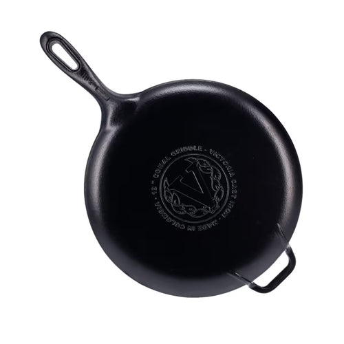 Vista de la base de la plancha redonda para pizza Victoria de 30 cm en hierro fundido esmaltado con el logo de la marca y origen de fabricación grabados, mango largo y asa de apoyo - Ferretería La Palma - 1050087