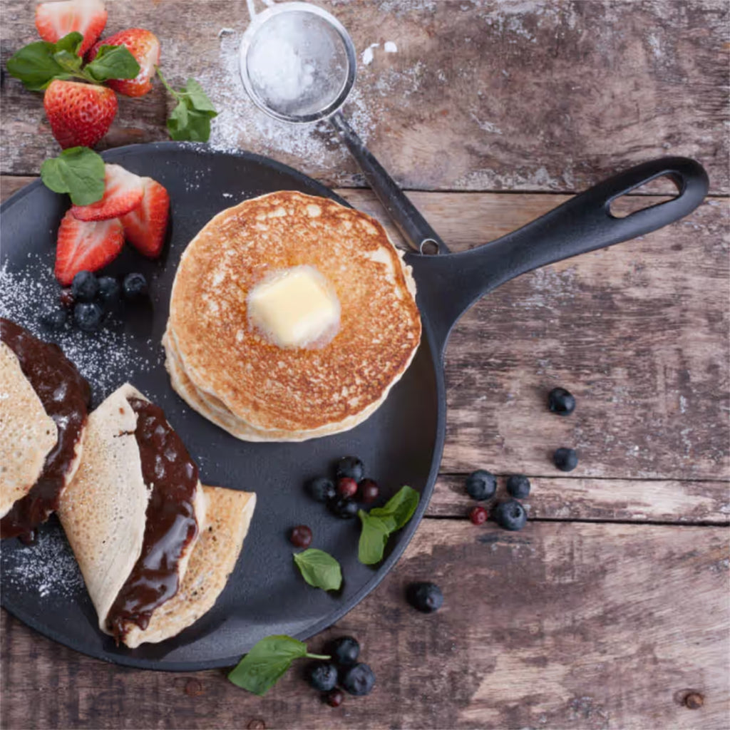 Sartén comal redondo Victoria de 26 cm en hierro fundido curado con pancakes con mantequilla, crepes rellenos de chocolate, fresas y arándanos - Ferretería La Palma - 1050024