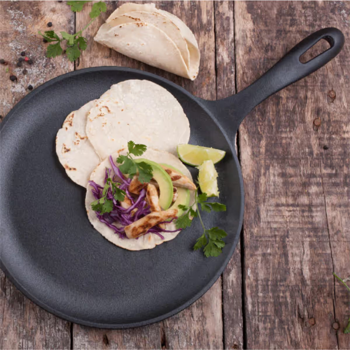 Sartén comal redondo Victoria de 26 cm en hierro fundido esmaltado con tacos de pollo, aguacate y repollo morado sobre una superficie de madera rústica - Ferretería La Palma - 1050025