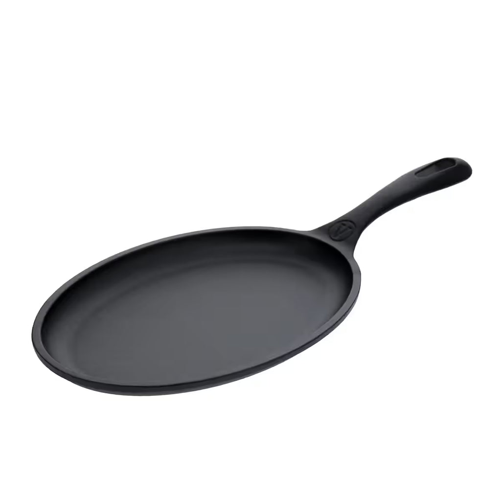 Vista en perspectiva del sartén para fajitas Victoria curado de 24 cm en hierro fundido curado destacando su diseño ovalado y mango curvo ergonómico - Ferretería La Palma - 1050060