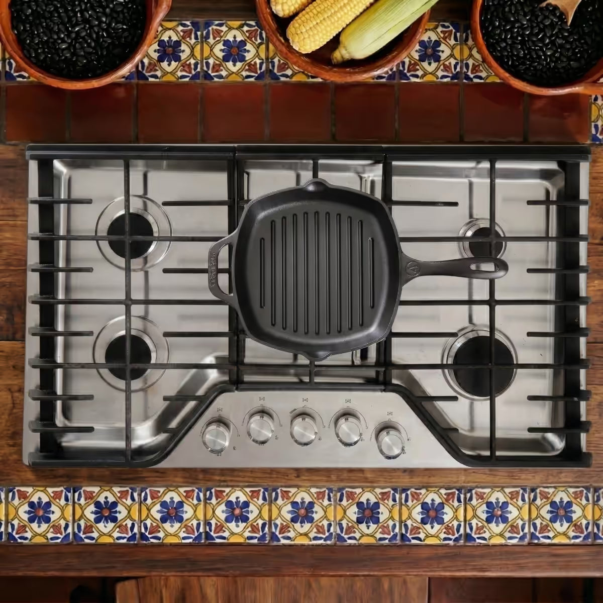 Vista cenital del sartén grill cuadrado Victoria de 25 cm en hierro fundido esmaltado sobre una estufa de gas en un ambiente de cocina tradicional - Ferretería La Palma - 1050027