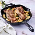 Sartén grill cuadrado Victoria de 25 cm en hierro fundido esmaltado con dos cortes de carne sellados, papas rústicas y romero fresco - Ferretería La Palma - 1050027