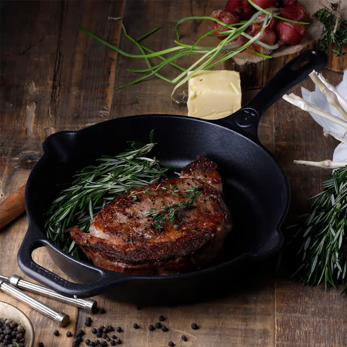 Sartén Victoria de 25 cm en hierro fundido curado con un corte de carne sellado y romero en ambiente de cocina rústica - Ferretería La Palma - 1050033