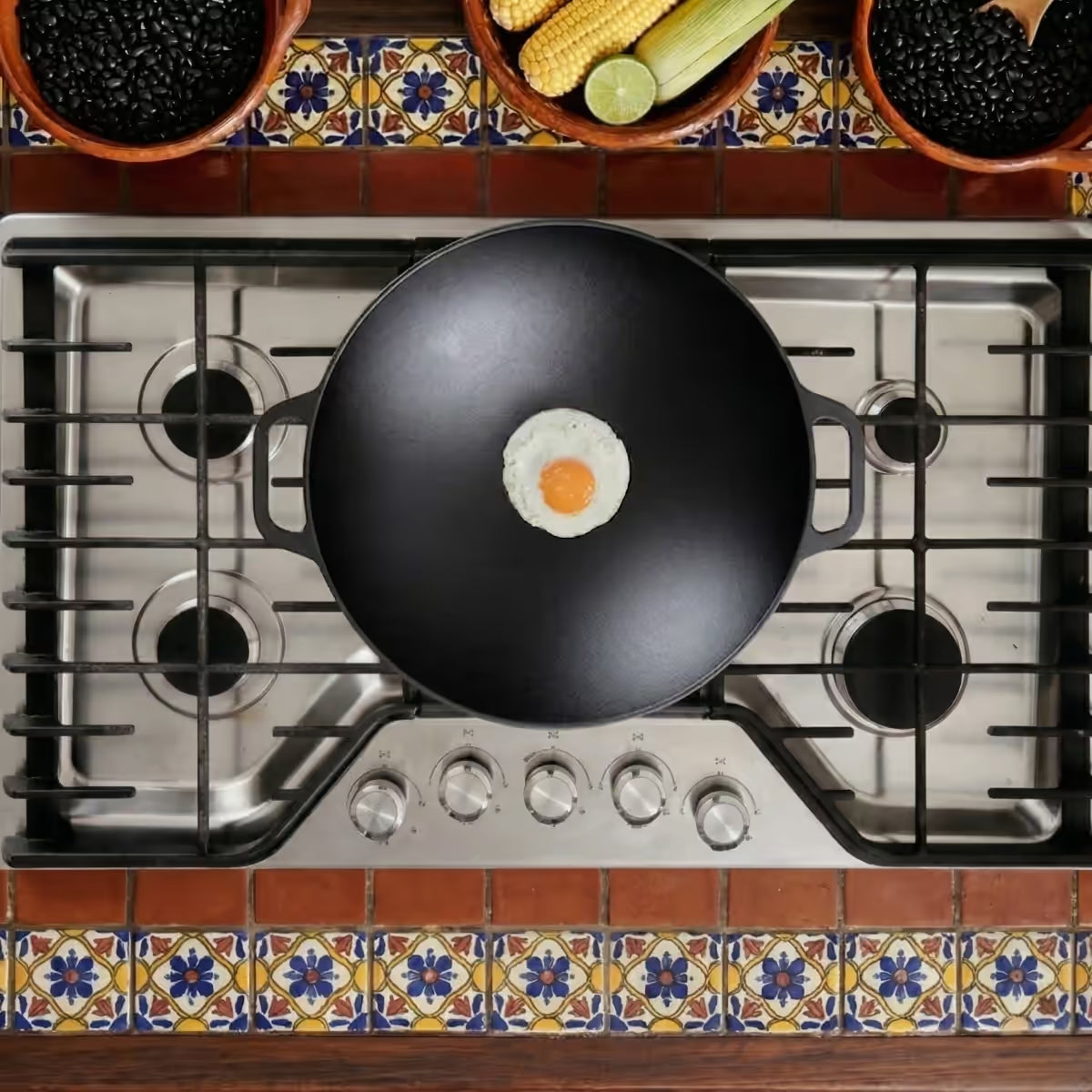 Vista cenital del sartén wok Victoria de 35.5 cm en hierro fundido esmaltado con un huevo frito sobre una estufa de gas en un ambiente de cocina tradicional - Ferretería La Palma - 1050038