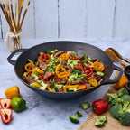 Sartén wok Victoria de 35.5 cm en hierro fundido esmaltado con un colorido salteado de carne, brócoli y pimientos sobre una superficie de mármol - Ferretería La Palma - 1050038