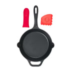 Vista cenital del set de sartén redondo Victoria de 23 cm en hierro fundido esmaltado mostrando sus componentes por separado: sartén, protector de mango de silicona rojo y raspador de limpieza - Ferretería La Palma - 1050148