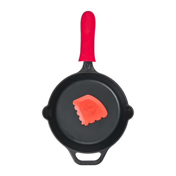 Vista cenital del set de sartén redondo Victoria de 23 cm en hierro fundido esmaltado con protector de mango de silicona rojo y raspador de limpieza - Imágen con fondo transparente - Ferretería La Palma - 1050148