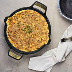 Paellera Victoria Signature 33 cm con un gratinado de pasta y queso espolvoreado con cebollín sobre una superficie de mármol - Ferretería La Palma - 1050093