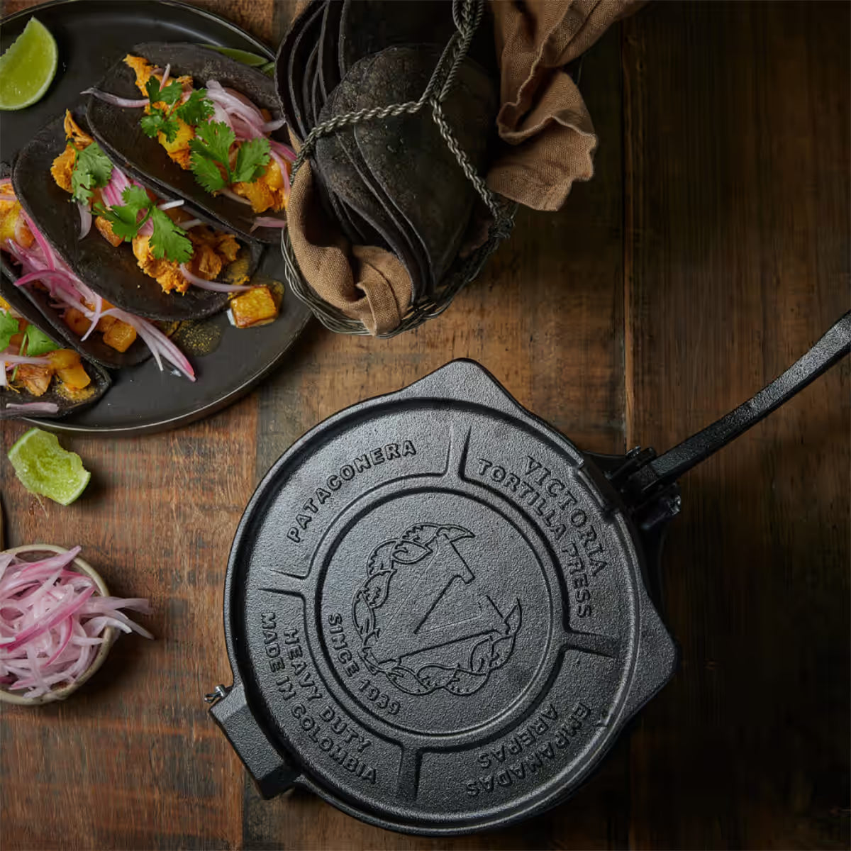 Tortillero Victoria Heavy Duty de 20 cm (o pulgadas) en mesa de madera junto a tacos de tortilla negra y cebolla curtida - Ferretería La Palma - 1050146
